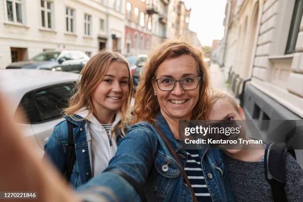 portrait of smiling mother and children taking selfie at roadside during weekend - selfie girl stock pictures, royalty-free photos & images
