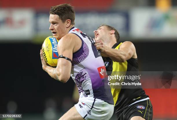 Matt Taberner of the Dockers is challenged by Jake Aarts of the Tigers during the round 15 AFL match between the Richmond Tigers and the Fremantle...