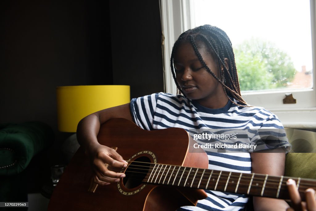 Teenage girl playing her guitar