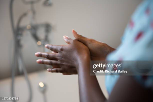 young woman moisturising her hands and arm with cream - damaged skin stock pictures, royalty-free photos & images