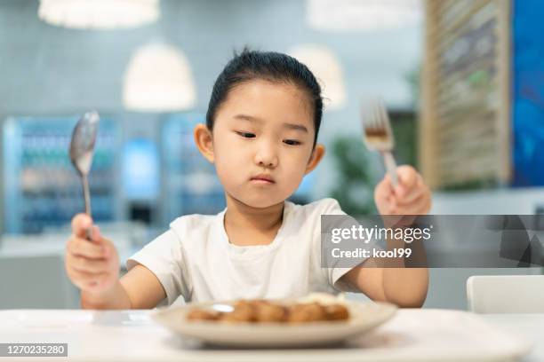 meisje dat voedsel zonder eetlust bekijkt - picky eater stockfoto's en -beelden