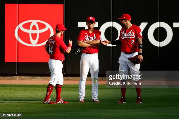 Mark Payton of the Cincinnati Reds, Shogo Akiyama and Nicholas Castellanos stand in the outfield between innings during the game against the Chicago...