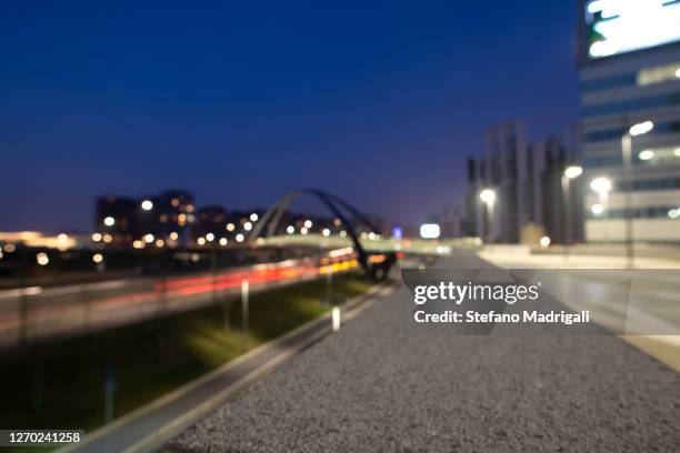 city mobility and nightlife. street with trails of moving car lights, in the modern city center of milan. - milan city stock pictures, royalty-free photos & images