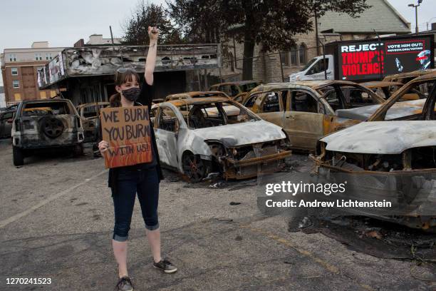 Black Lives Matter supporter poses for a photograph in a car dealership burnt in last week's rioting, on September 1 in Kenosha, Wisconsin. President...