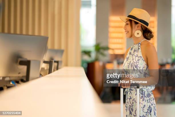 female traveler waiting to check-in at front desk in luxury hotel. - airport lounge luxury stockfoto's en -beelden