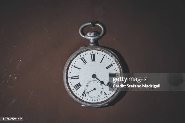 metal clock with hands, antique vintage style on uniform and dark background - pocket watch stock pictures, royalty-free photos & images