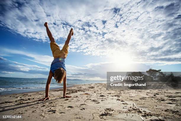little boy doing handstand on beach - handstand stock pictures, royalty-free photos & images