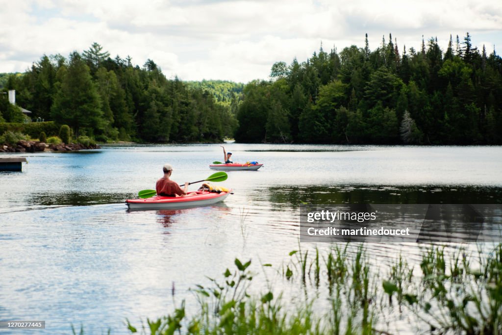 Millennial couple kayaking on country lake.