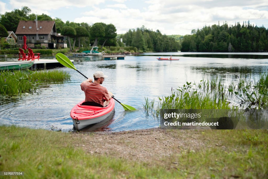 Millennial couple kayaking on country lake.