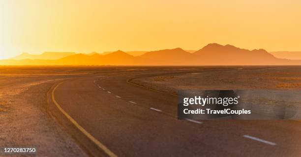 amazing sunlight near monument valley, arizona, usa. view of historic u.s. route 163 running through famous monument valley in beautiful golden evening light at sunset on a beautiful sunny day with blue sky in summer, utah, usa - arizona mountains stock pictures, royalty-free photos & images