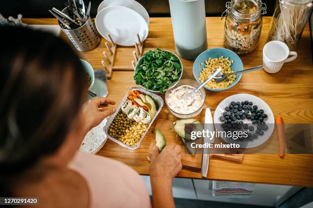 frau kocht essen in der küche - lunch box stock-fotos und bilder