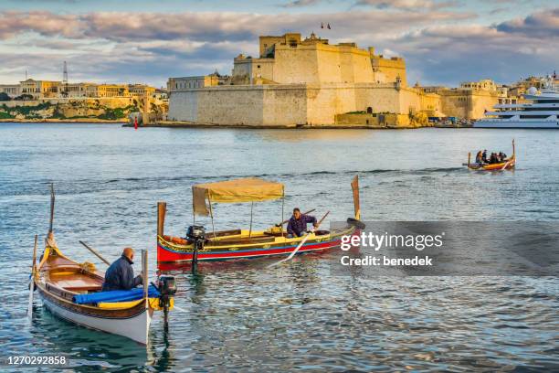 traditional maltese dghajsa boats in valletta malta - water taxi stock pictures, royalty-free photos & images