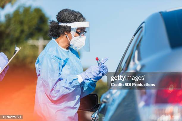 l'operatore sanitario femminile spiega il test covid alla paziente - operatore di prima linea foto e immagini stock