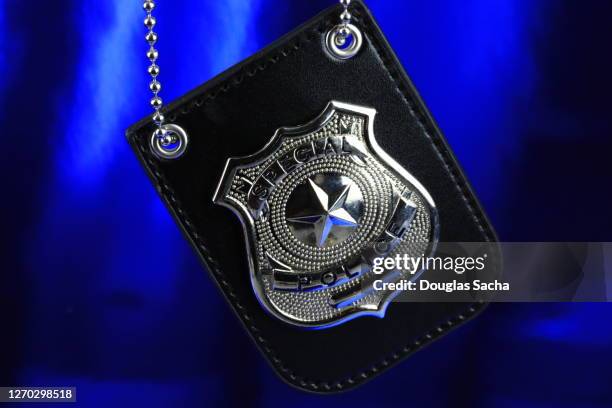 police badge on a blue background - police uniform stock pictures, royalty-free photos & images