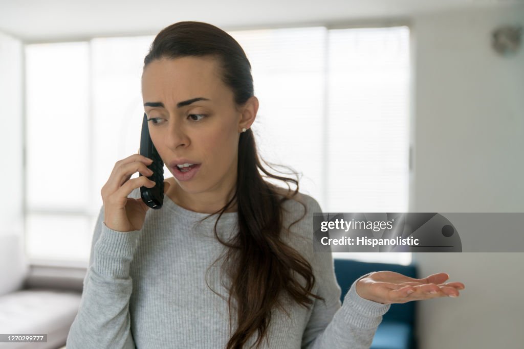 Vrouw thuis die op de telefoon debatteert