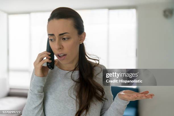 mulher em casa discutindo ao telefone - complaining - fotografias e filmes do acervo