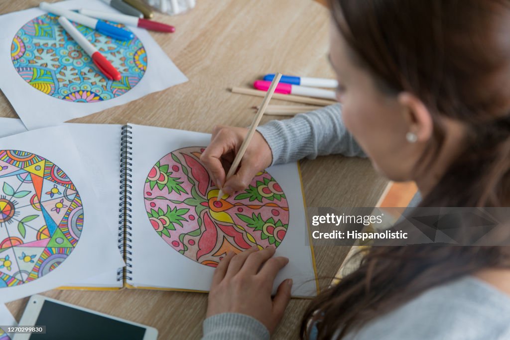 Primer plano en una mujer coloreando mandalas en casa