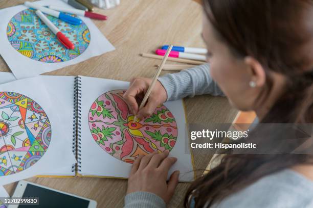 close-up on a woman coloring mandalas at home - coloring stock pictures, royalty-free photos & images