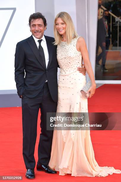 Adriano Giannini and Gaia Trussardi walk the red carpet ahead of the Opening Ceremony and the "Lacci" red carpet during the 77th Venice Film Festival...
