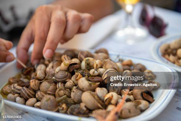 male hands taking cooked snails from a plate - snail stock pictures, royalty-free photos & images