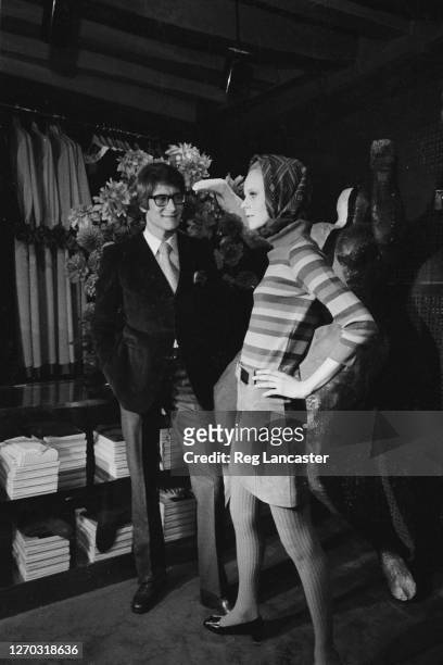 French fashion designer Yves Saint Laurent at his boutique in Paris, France, with actress and customer Catherine Deneuve, 26th September 1966.