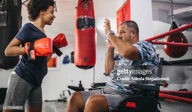 Joven entrenador enseña a los niños deporte de boxeo en el gimnasio.