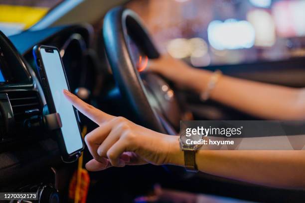 aziatische vrouw e-hailing bestuurder die gezichtsmasker draagt gebruikend smartphone - uber stockfoto's en -beelden