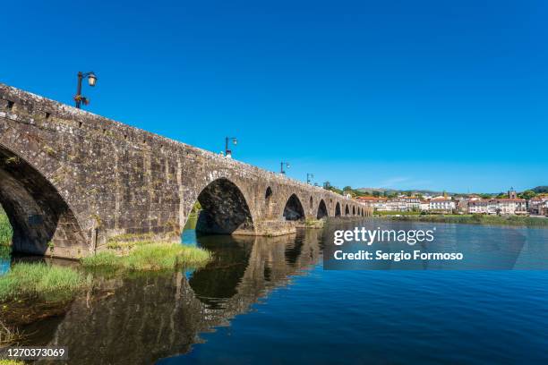 landmark, 31 arches pedestrian stone bridge from roman and medieval times on the lima river, ponte de lima, portugal - ponte de lima stock pictures, royalty-free photos & images
