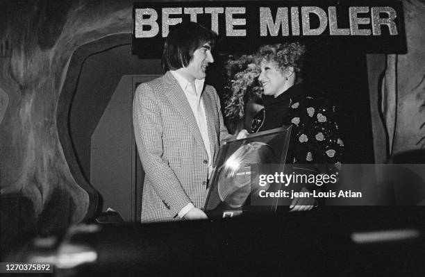 Le chanteur français Serge Lama avec l'actrice américaine Bette Midler lors de sa remise du disque d'or.