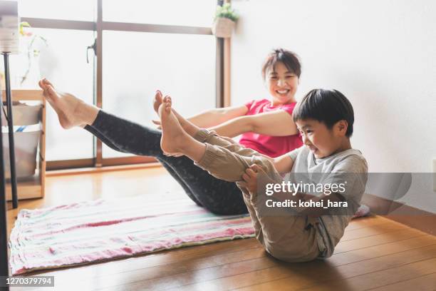 mère et fils exerçant le yoga ensemble à la maison - family yoga photos et images de collection