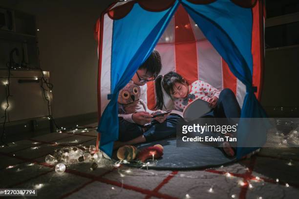 asian chinese child playing in the playroom in the tent with her brother - kids fort stock pictures, royalty-free photos & images