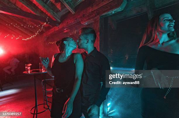 young couple kissing in night club - entertainment club stock pictures, royalty-free photos & images