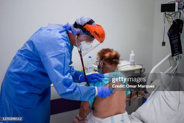 Doctor wears a protective suit, mask, gloves and a face shield as she checks the lungs of a COVID-19 patient at the Krakow University Hospital on...