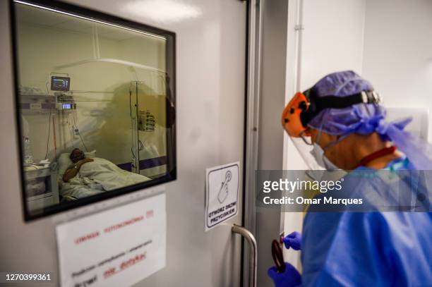 Doctor wears a protective suit, mask, gloves and a face shield as she checks the lungs of a COVID-19 patient at the Krakow University Hospital on...