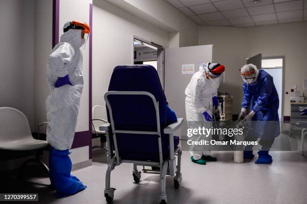 Medical personnel wear protective suits, masks, gloves and face shields as they administrate oxygen to a possible COVID 19 patient during their shift...