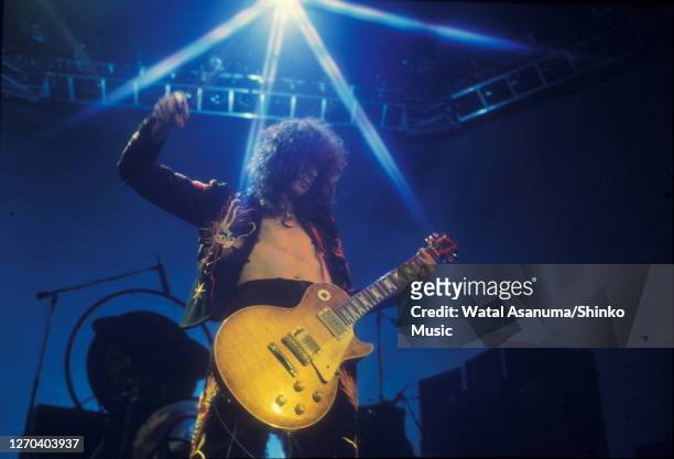 Jimmy Page of Led Zeppelin performing on stage at Earl's Court, London, May 1975. He is playing a Gibson Les Paul Standard guitar with a bow.