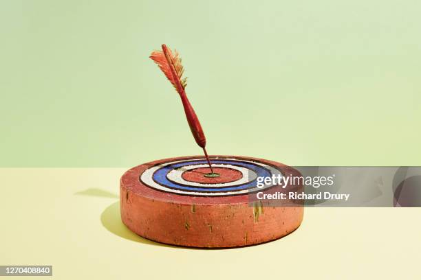 a dart in the bullseye of a dart board - dart board stock-fotos und bilder