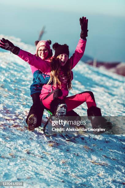 sleigh fun for female kids on snowy mountain - bobsleigh stock pictures, royalty-free photos & images