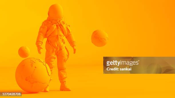 concetto immagine stereoscopica. modello low poly terra e astronauta isolato su sfondo arancione. - copy space foto e immagini stock