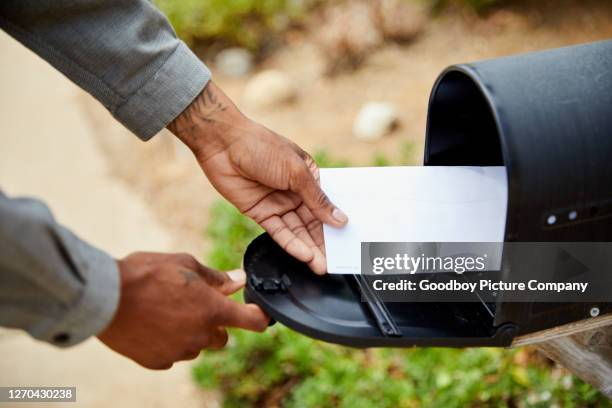 uomo che toglie una busta dalla sua casella di posta - mailbox foto e immagini stock