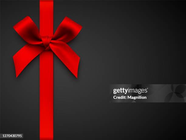 red gift bow with ribbon on a black background - black ribbon stock illustrations