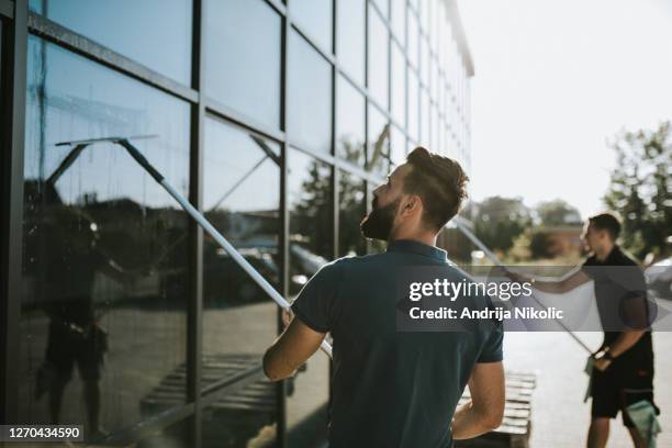 limpiadores de ventanas trabajando juntos - limpieza profesional fotografías e imágenes de stock