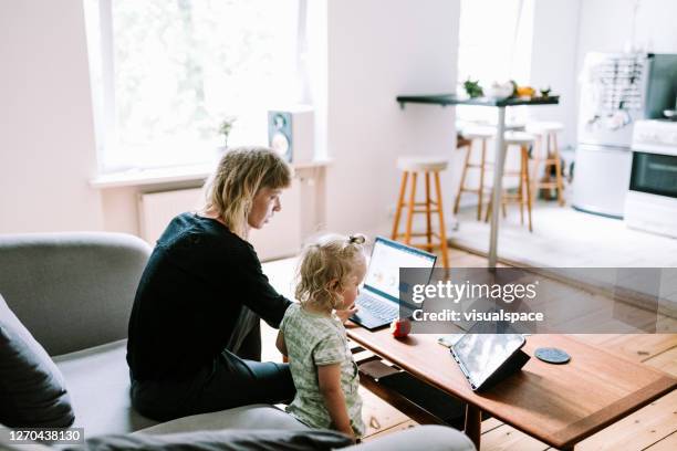 joven madre con hijo trabaja en la oficina en casa - leanincollection working women fotografías e imágenes de stock