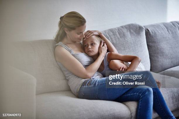 mother consoling sad son on couch at home - boy hugs mother stock pictures, royalty-free photos & images