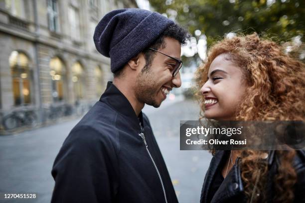 happy young couple in the city looking at each other - tomber amoureux photos et images de collection