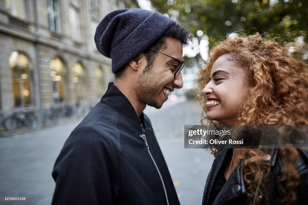 Happy young couple in the city looking at each other