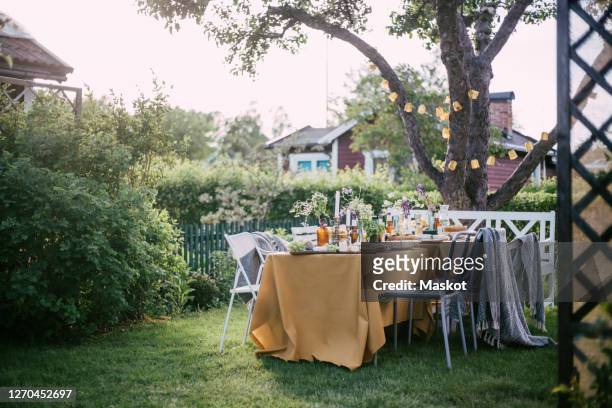 chairs arranged by table at backyard during garden party - garden party stock-fotos und bilder