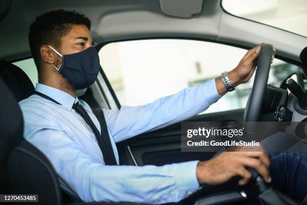 homem dirigindo um carro durante a pandemia - driving mask - fotografias e filmes do acervo
