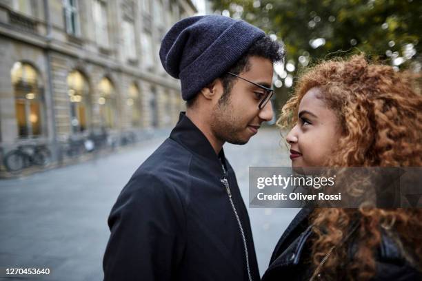 young couple in the city looking at each other - teenage romance stock pictures, royalty-free photos & images