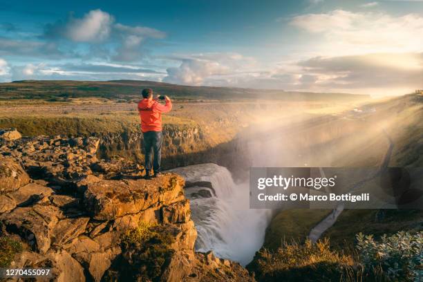 tourist photographing gullfoss waterfall, iceland - cultura islandesa fotografías e imágenes de stock